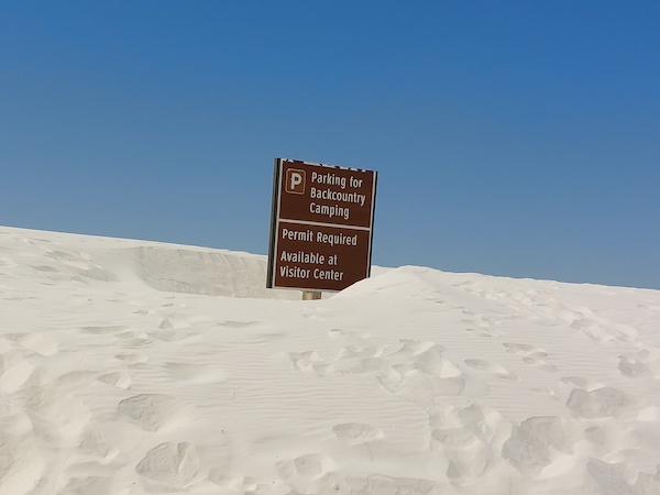 Image of a sign, almost buried by the drifting.